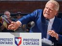 Ontario Premier Doug Ford empties a bottle of Crown Royal during a press conference in Kitchener, Sept. 2, 2025.  (The Canadian Press)