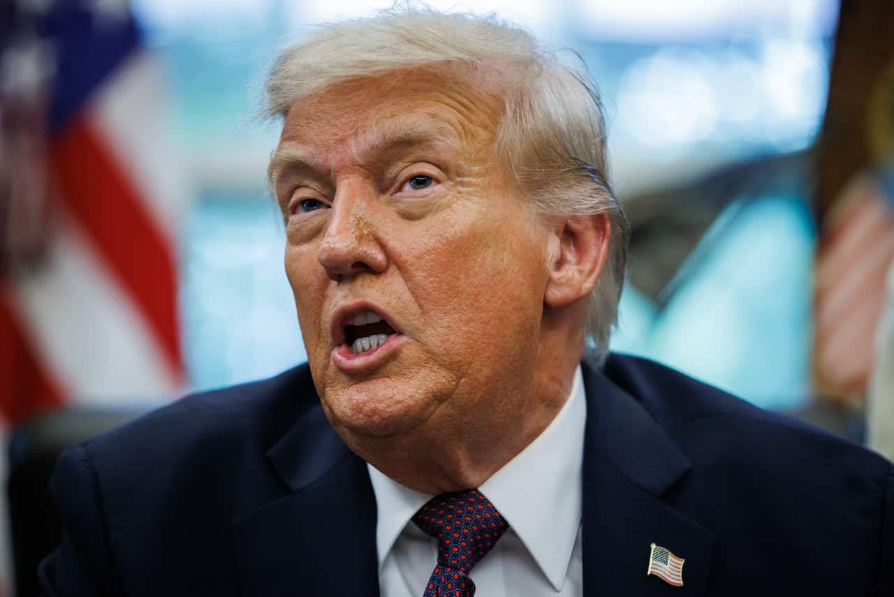 Donald Trump wearing a dark blue jacket with an American flag pin on it.