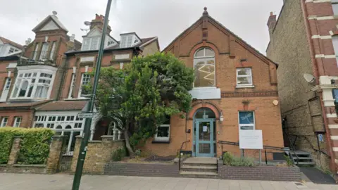 Google Streetview image of the nursery, a red brick building with a sign outside