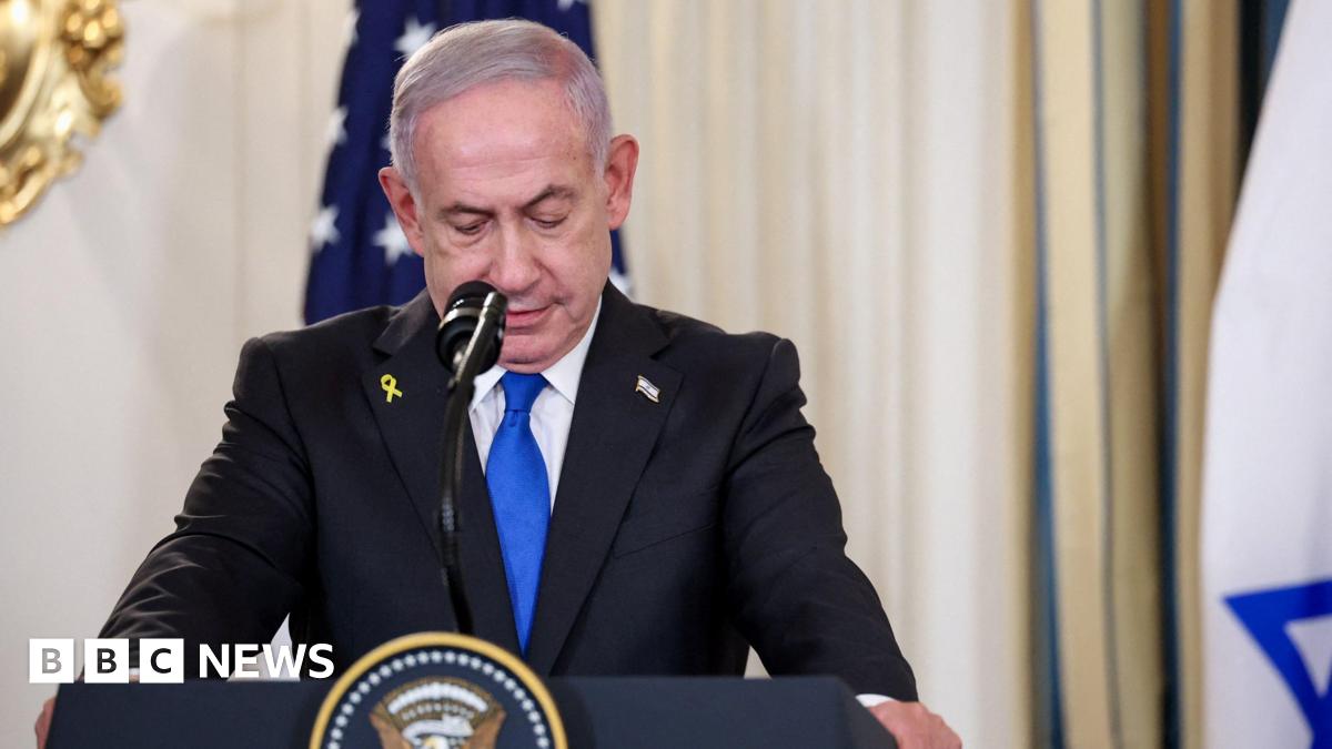 Netanyahu at a podium wearing a suit, looking down.
