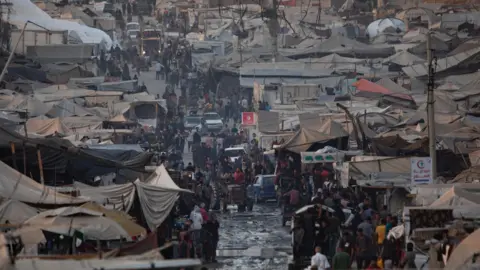 EPA Displaced Palestinians flee with their belongings to a camp along al-Rasheed Street, west of Gaza City (2 September 2025)