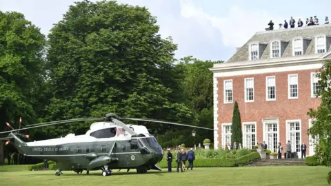 MANDEL NGAN/AFP via Getty Images A US helicopter lands in the gardens of the stately home