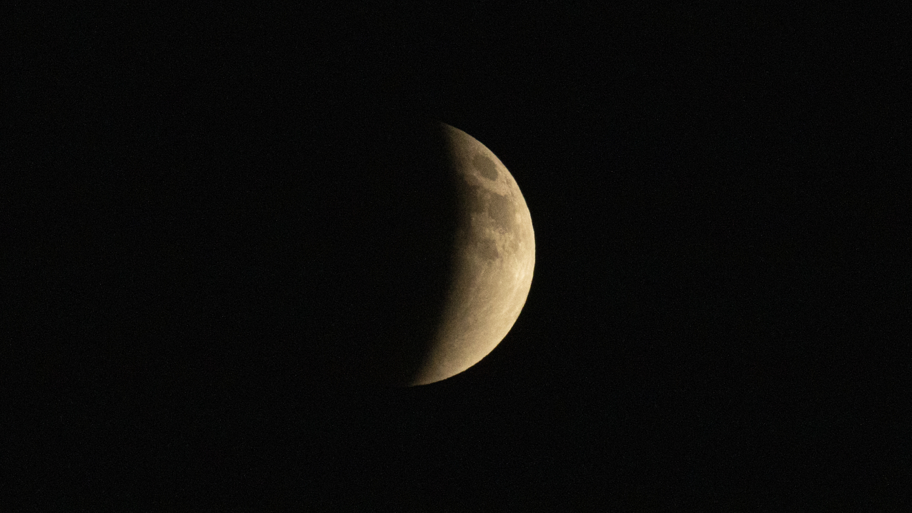 The moon is pictured with its right half lit and its left bathed in shadow.
