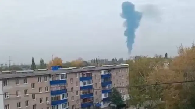 A plume of smoke rises high into the sky
