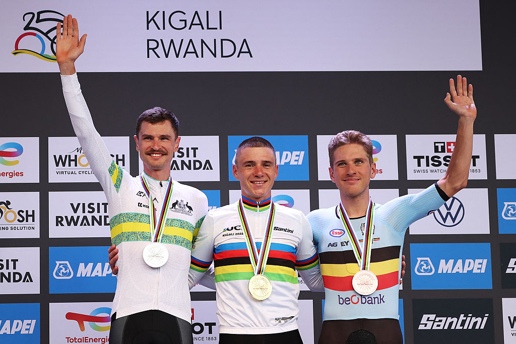 Silver medallist Australian rider Jay Vine (L), gold medallist Belgian rider Remco Evenepoel (C) and bronze medallist Belgian rider Ilan van Wilder (R) pose on the podium following the men's Elite Individual Time Trial cycling event during the UCI 2025 Road World Championships, in Kigali, on September 21, 2025. (Photo by Anne-Christine POUJOULAT / AFP)