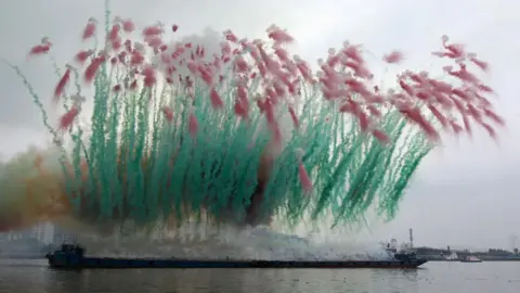 Getty Images People watch a fireworks presented by Chinese artist Cai Guo-Qiang during day time near Huangpu river on August 8, 2014 in Shanghai, China.