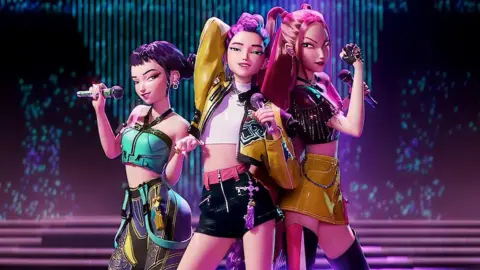 Netflix Huntrix from the Netflix animated film KPop Demon Hunters. They are three animated female characters dressed in K-pop style clothing and holding microphones. All three have purple/pink hair.