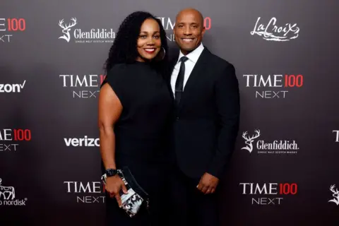 Getty Images  Victor Glover wears a suit and tie while posing next to an unnamed woman on the red carpet as he attends the 2023 Time100 Next at Second on October 24, 2023 in New York City.
