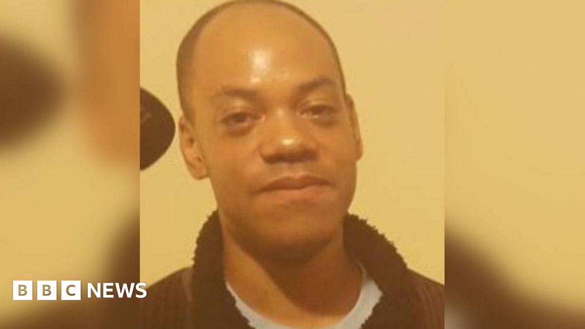 Junior Ryan Coleman with short hair is pictured indoors against a cream wall. He is wearing a dark zip-up jacket over a light blue top and looking towards the camera.