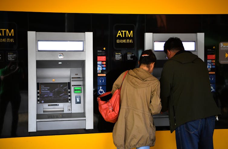 Customers using a Commonwealth Bank ATM in Adelaide