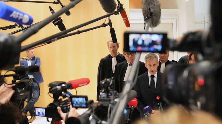 Former French President Nicolas Sarkozy speaks with the media after a Paris court sentenced him to 5 years after finding him guilty of criminal conspiracy in an alleged scheme to finance his 2007 campaign with funds from Libya