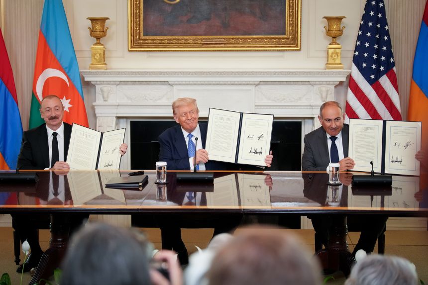 Trump (C), Azerbaijani President Ilham Aliyev (L), and Armenian Prime Minister Nikol Pashinyan (R) hold up an agreement signed at the White House on August 8, 2025.