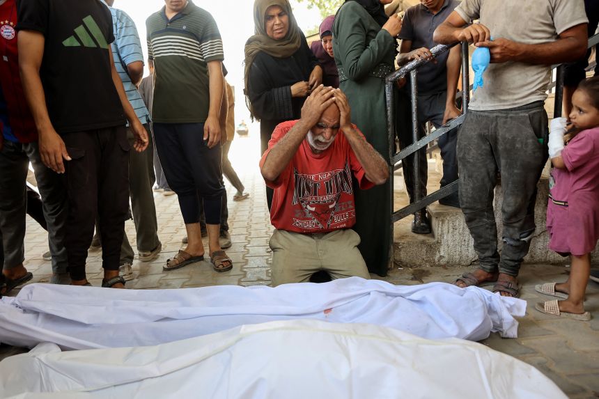 A Palestinian man mourns over the shrouded bodies of family members killed in an Israeli strike on a makeshift bakery housed in a tent on Al-Nassr Street in Gaza City on Saturday.