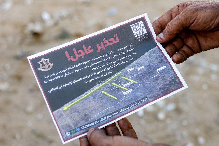 A man holds one of the leaflets dropped by the Israeli military on Gaza City, urging evacuation south to al-Mawasi, on September 9, 2025.