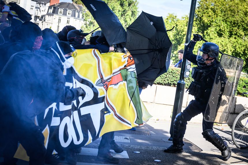 An anti-riot officer waves his baton at protesters during an an austerity demonstration in Nantes, France, on September 18.