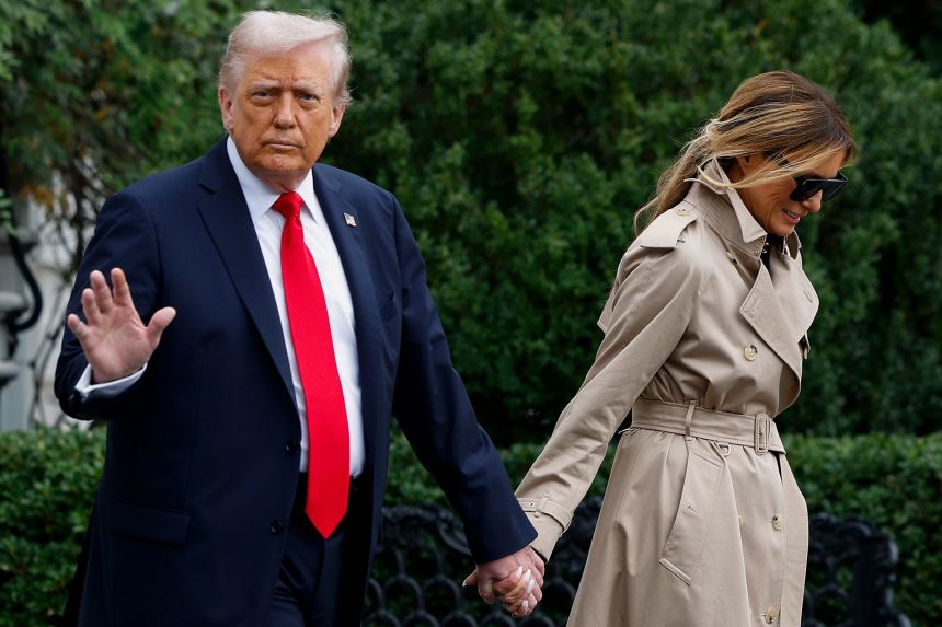 First lady Melania Trump holds President Donald Trump's hand as they depart the White House en route to London on Tuesday.