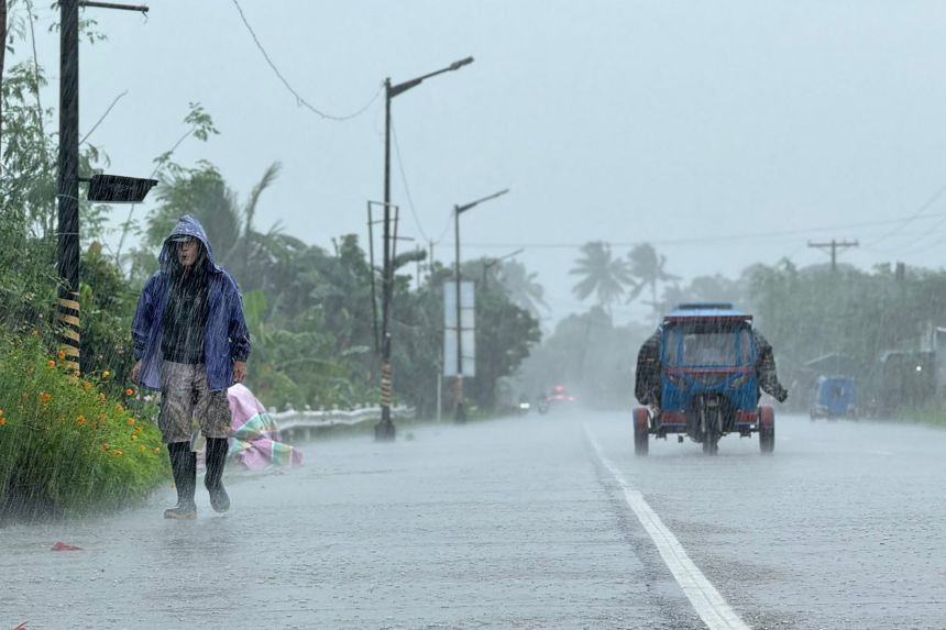 A man walks along a road amid heavy rain due to Super Typhoon Ragasa in Lal-lo town, Cagayan province on September 22, 2025.