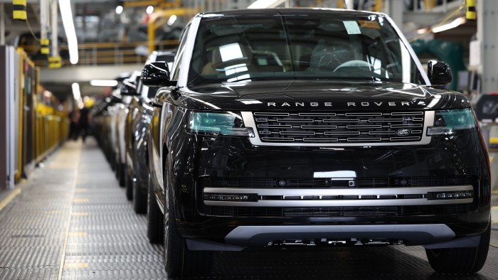 A black Range Rover SUV on a production line with several other vehicles at the Jaguar Land Rover plant in Solihull.