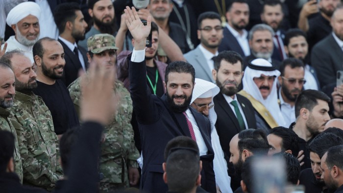 Syria’s interim President Ahmed al-Sharaa waves as he attends the ‘Aleppo, Key to Victory’ celebration in Aleppo in May