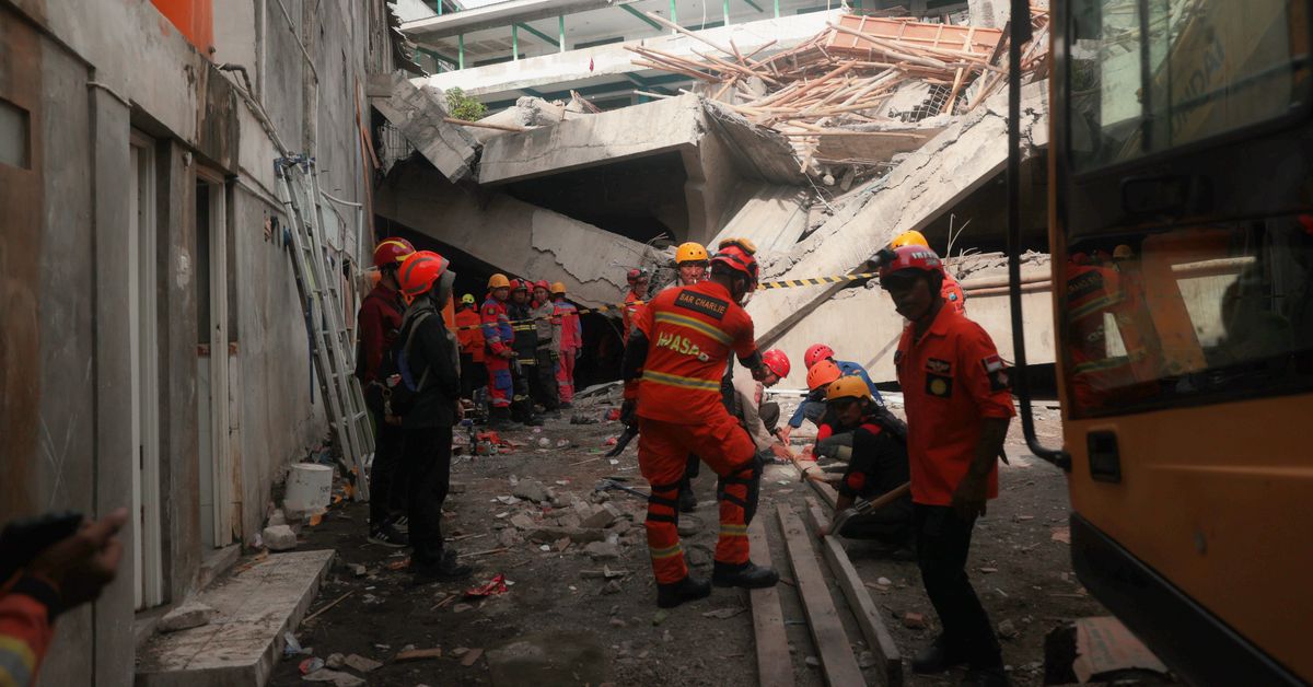 Rescuers run oxygen to survivors in school building collapse