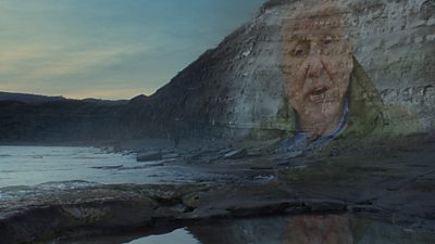 Footage of Sir David Attenborough is projected on cliffs