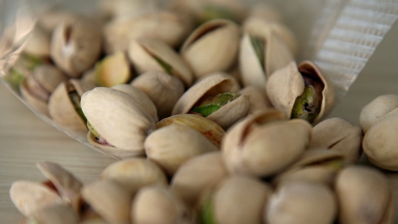 A bag of pistachio nuts with shells.