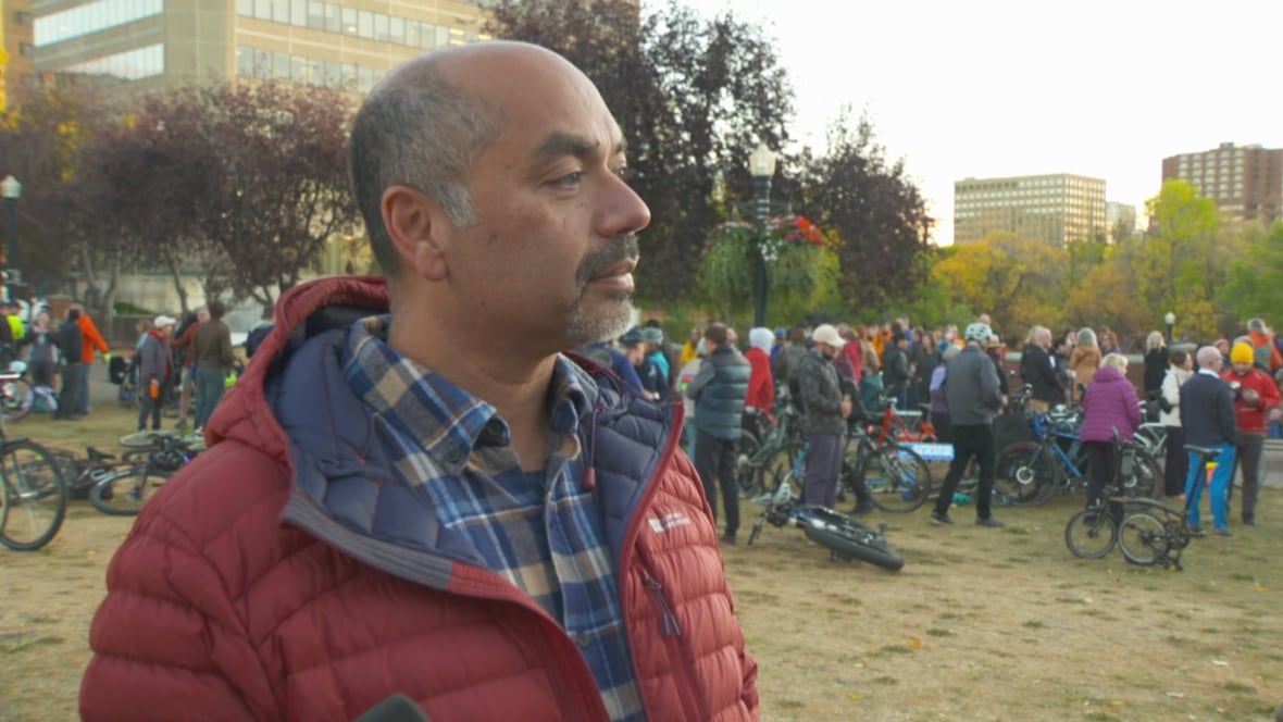 man in a red jacket looking off to the side on front of a crowd