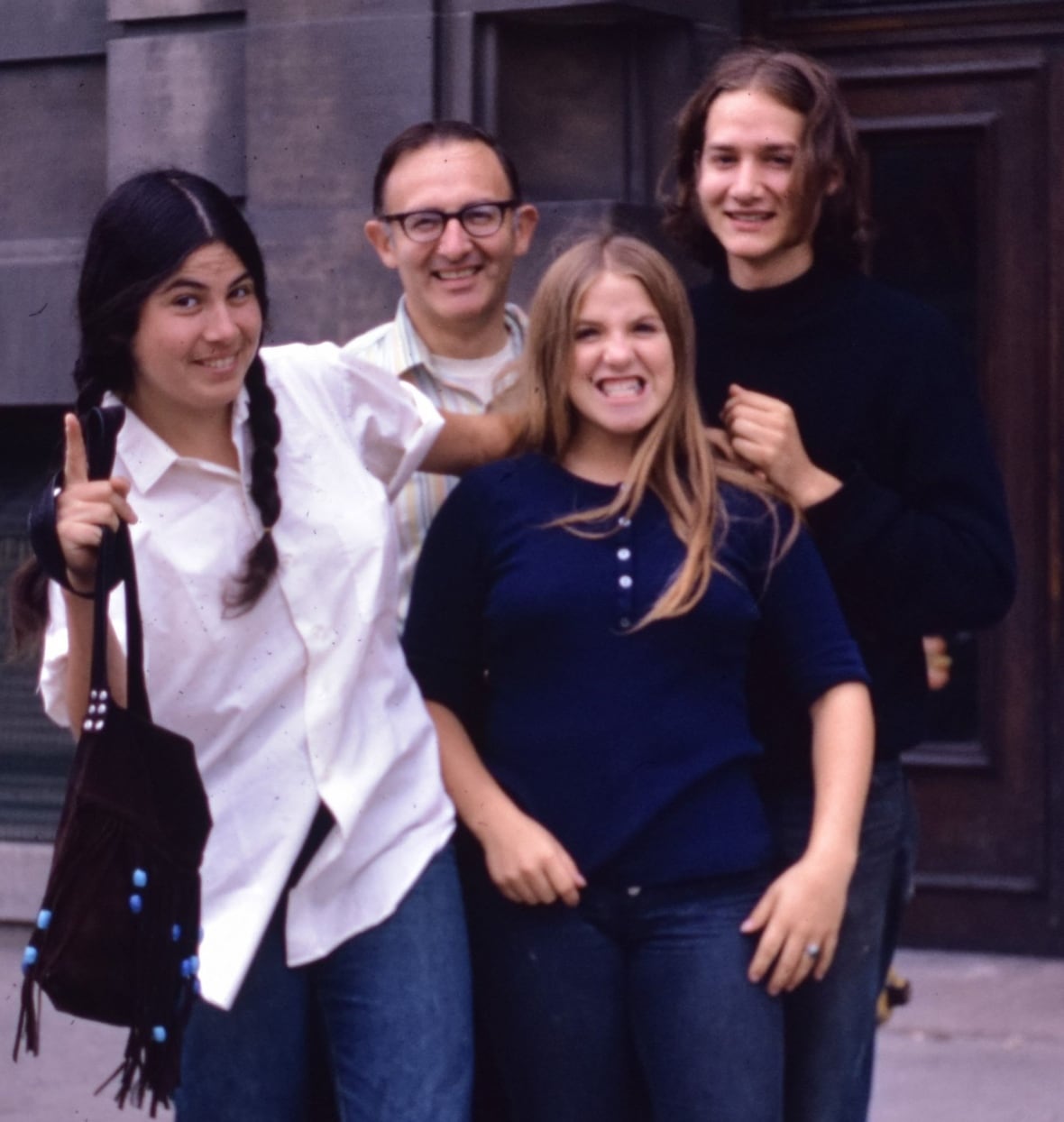 A father with a son and two daughters in a colour photo from the 1970s.