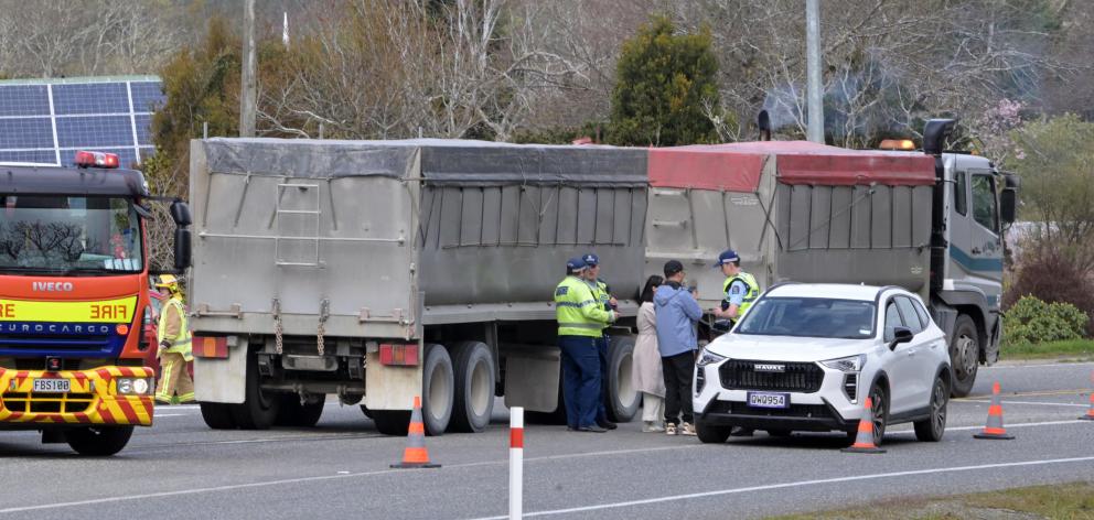 Police speak to the driver of a car involved in a collision with a truck and trailer at the...