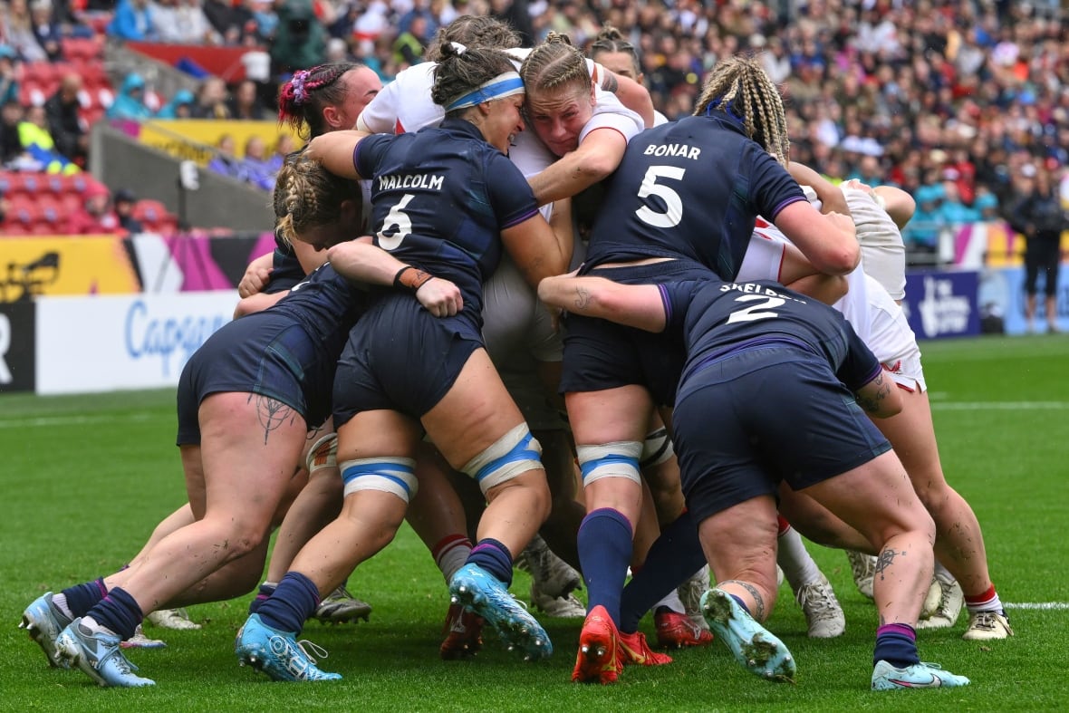 A group of athletes mashed togethed in ascrum