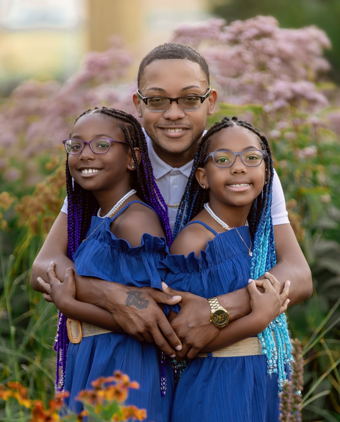 Samuel Provo-Benoit poses with his arms around his twin daughters.