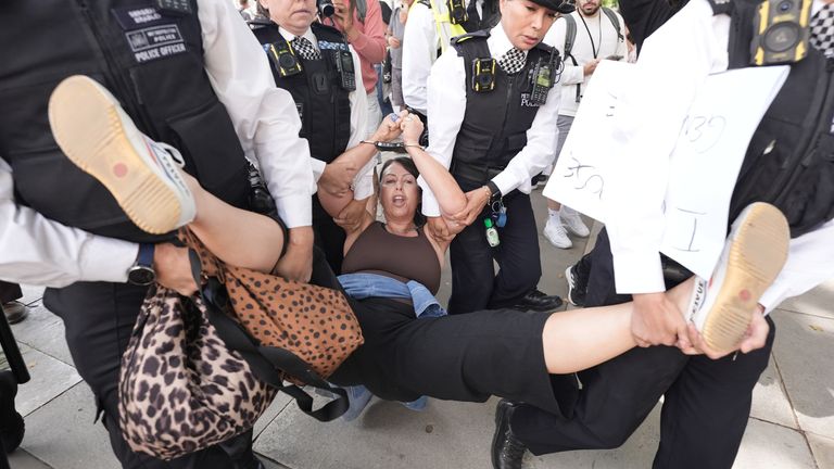 A woman is dragged away by police officers after attending the Palestine Action protest in Parliament Square in August. Pic: PA