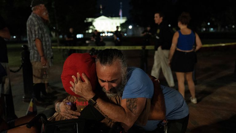Philipos Melaku-Bello is hugged near the vigil. Pic: Reuters