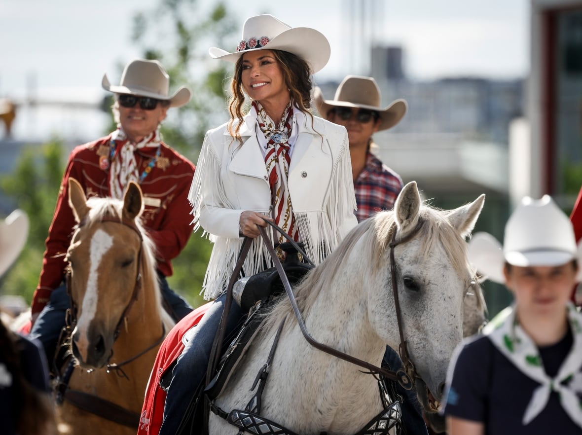 Parade Marshal Shania Twain, centre, rides a horse during the Calgary Stampede parade in Calgary.
