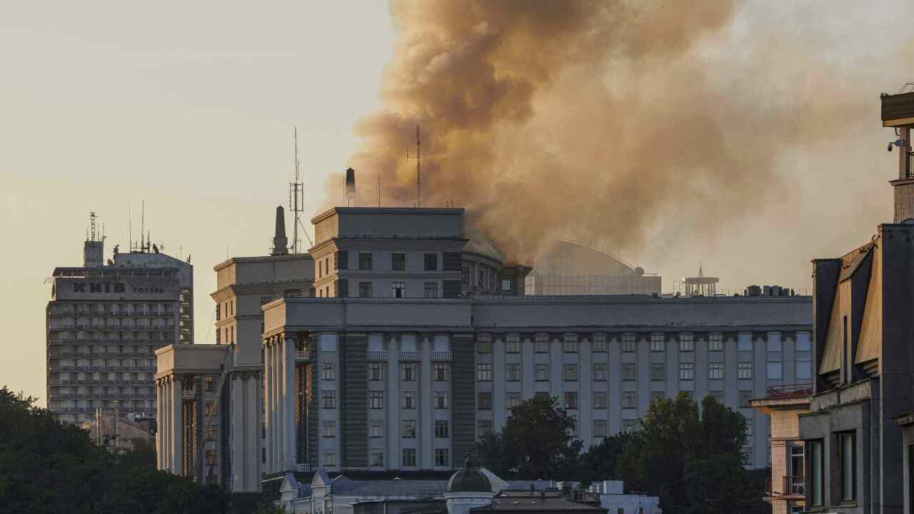 A building in the distance wih smoke coming from behind it
