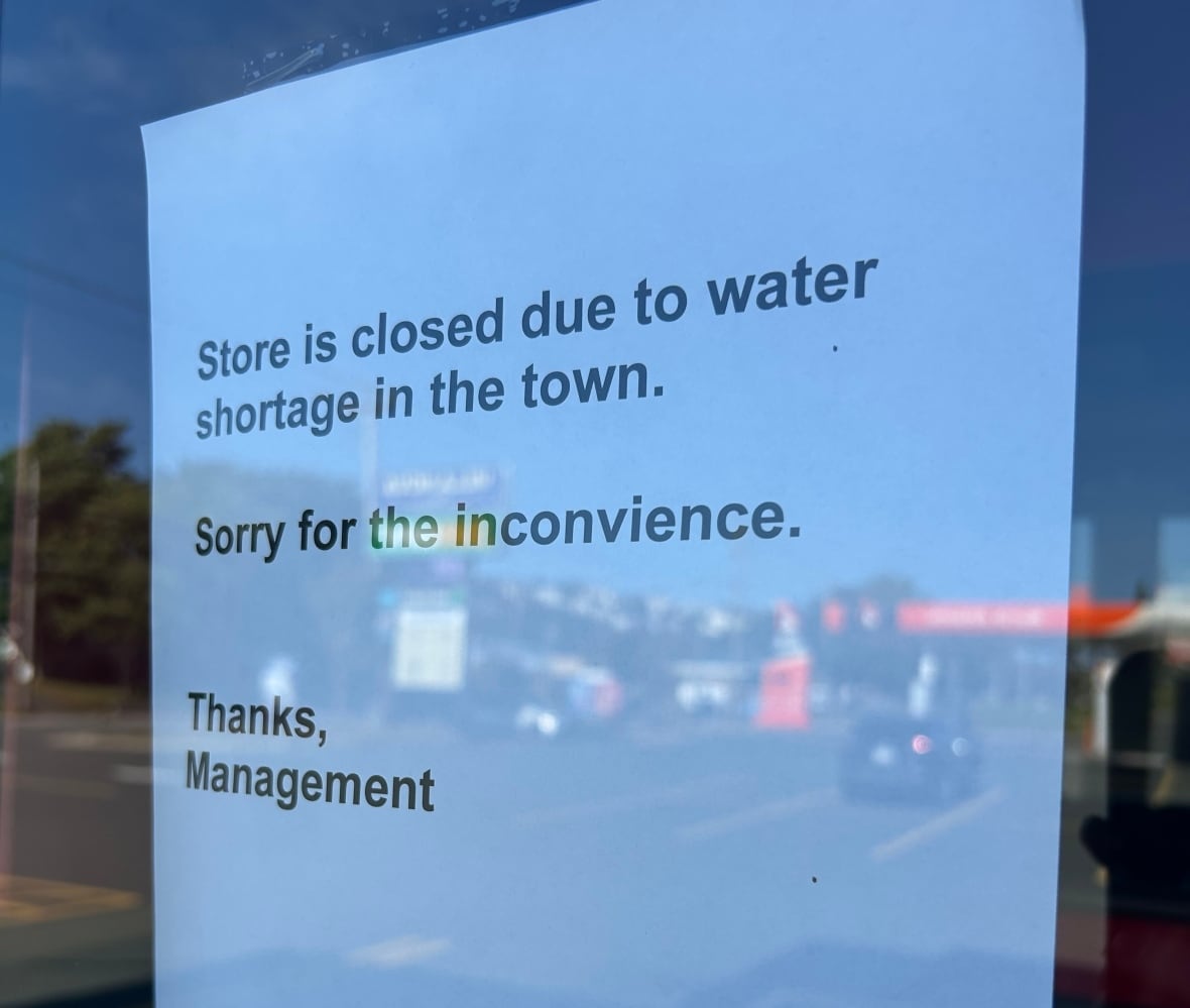A sign in the window of a pizza place reads 'Store is closed due to water shortage in the town. Sorry for the inconvenience. Thanks, management.'