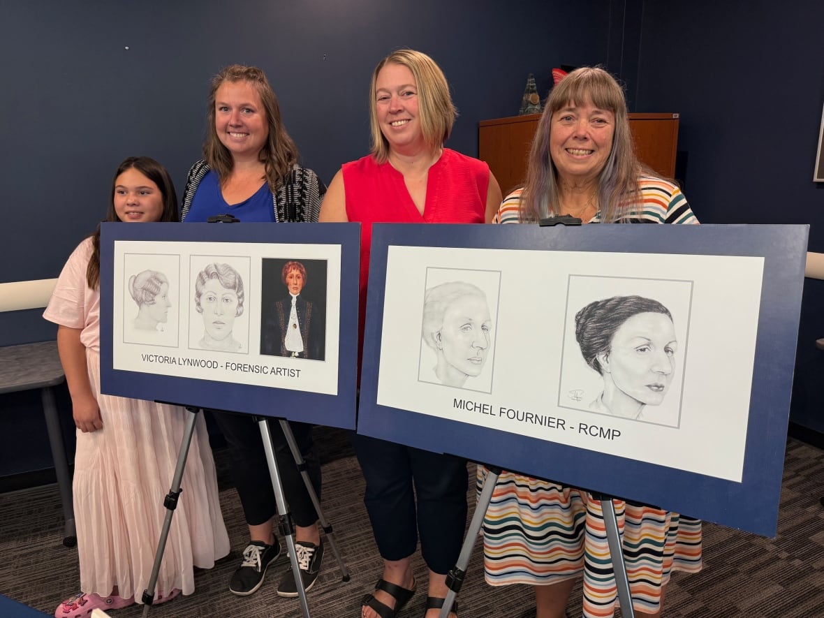 Three women and a girl pose for a photo while standing behind two police sketched on easels.