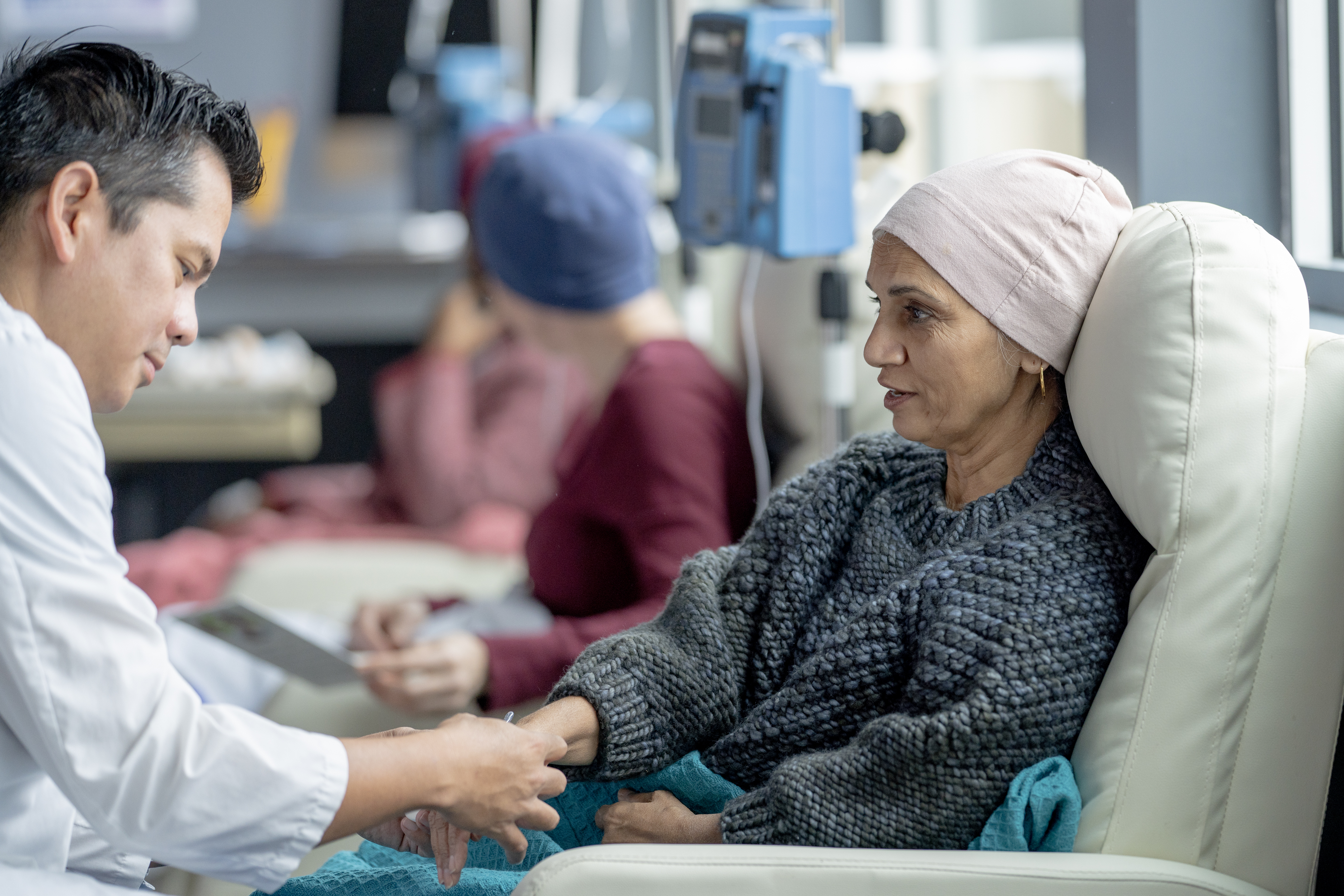 A small group of women, battling cancer, are sitting in treatment chairs in an Oncology clinic as they receive their Chemotherapy treatment.