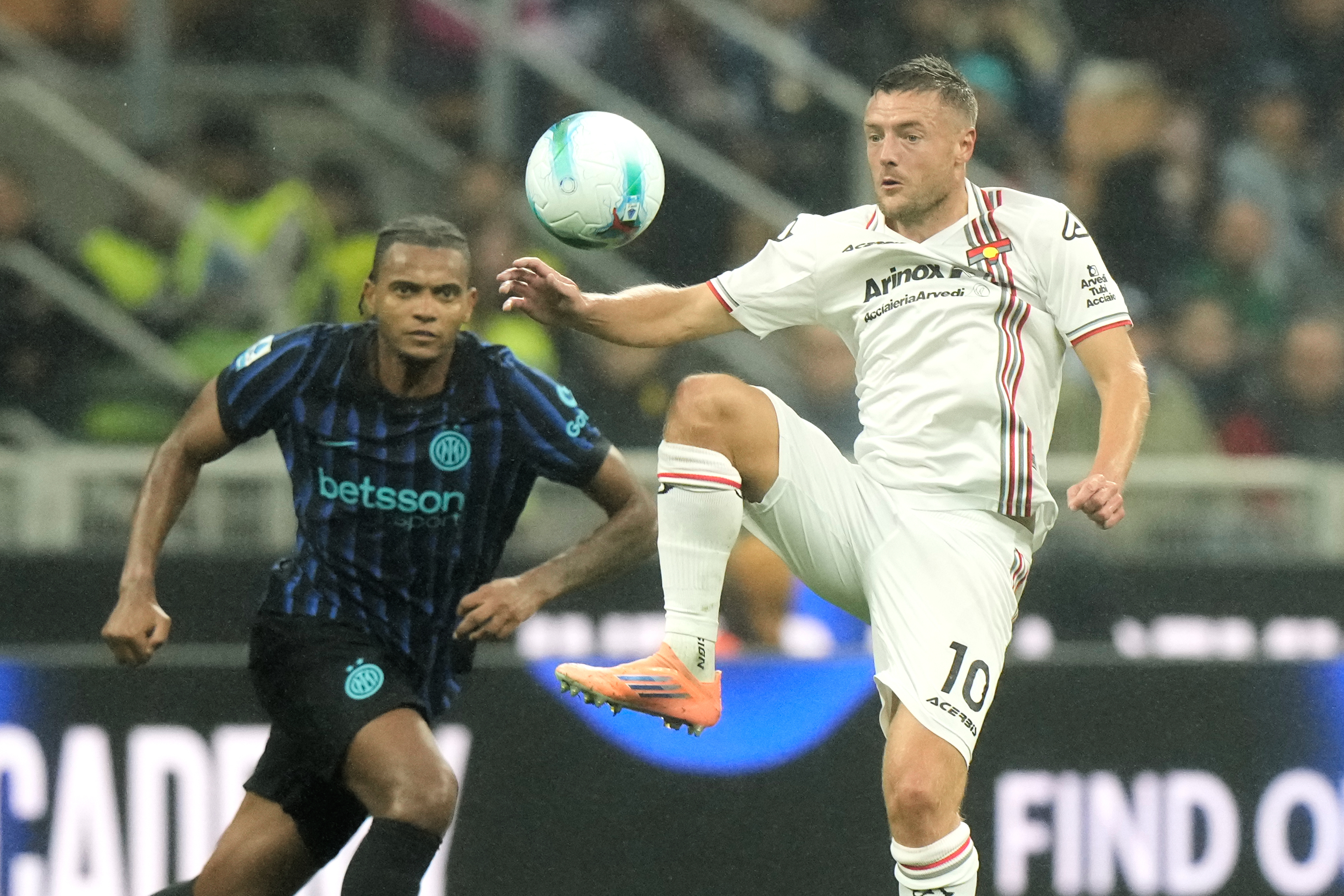 Cremonese's Jamie Vardy controls a soccer ball in the air ahead of Inter Milan's Manuel Akanji during a Serie A soccer match.