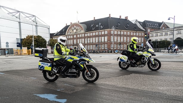 Police officers on motorbikes are in front of Christiansborg Palace in Copenhagen