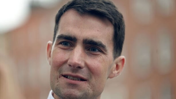 Jack Chambers speaking to media with a blured building behind him