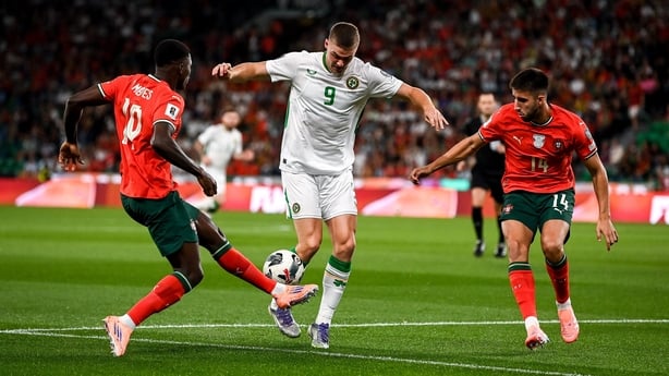 Evan Ferguson of Republic of Ireland in action against Nuno Mendes, left, and Goncalo Inácio of Portugal during the FIFA World Cup 2026 Group F qualifying match between Portugal and Republic of Ireland at Estádio José Alvalade in Lisbon, Portugal.