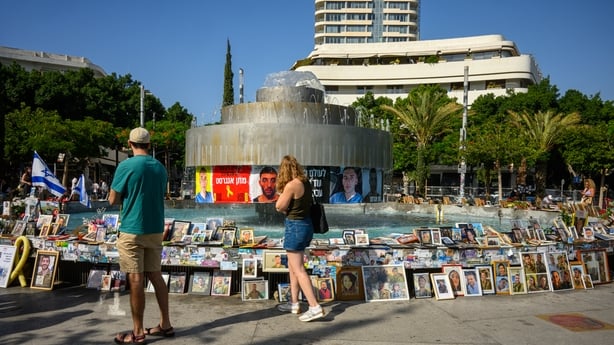 TEL AVIV, ISRAEL - OCTOBER 11: People visit a makeshift memorial filled with photos of victims and hostages of October 7th surrounding the Dizengoff Square fountain on October 11, 2025 in Tel Aviv, Israel. This week's ceasefire deal between Israel and Hamas has brought an end to the two years of war