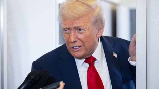 US President Donald Trump speaks with the media aboard Air Force One