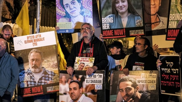Protesters stand with portraits of Israeli hostages including Eliyahu Margalit 
