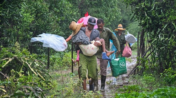 Residents evacuate under pouring rain from Playa Siboney to safe locations ahead of the arrival of Hurricane Melissa, in Santiago de Cuba