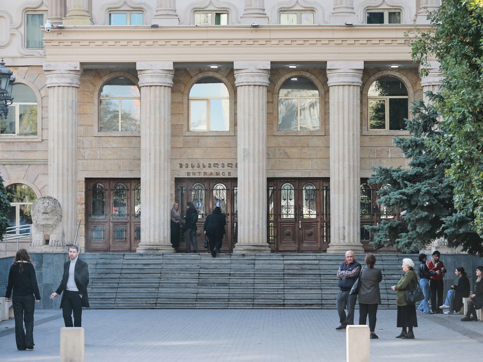 Lyanne Kennedy, background left, the mother of 19-year-old Bella May Culley who was arrested upon arrival at the Tbilisi Airport in May and accused of attempting to smuggle marijuana and hashish into the country, stands at an entrance as she arrives to attend the court session in Tbilisi, Georgia (Zurab Tsertsvadze/AP)