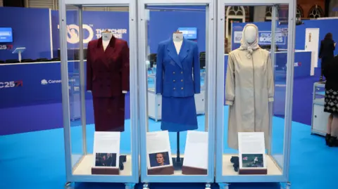 EPA Three display cabinets at Conservative party conference holding outfits worn by Margaret Thatcher.