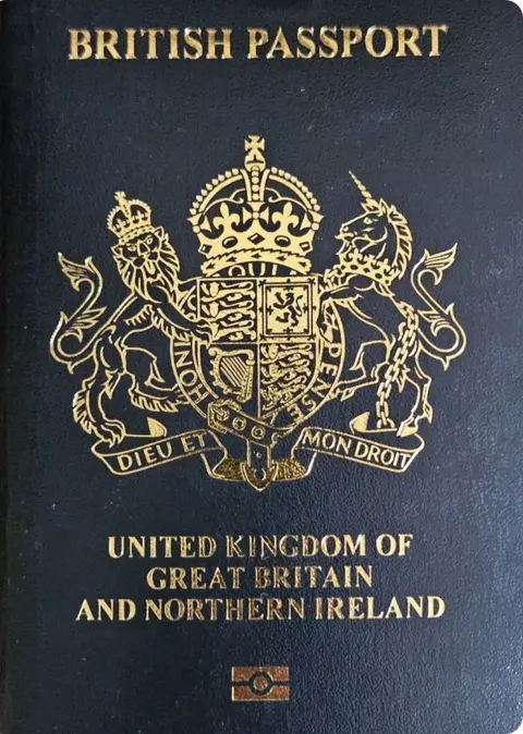 PA Media A close-up shot of the updated passport, which is dark blue with the coat of arms in gold.