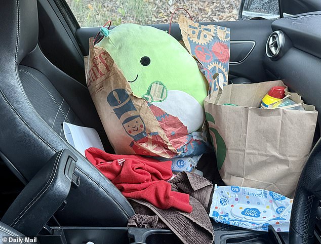 Children's toys, clothing, and other items could be seen inside the black Mercedes